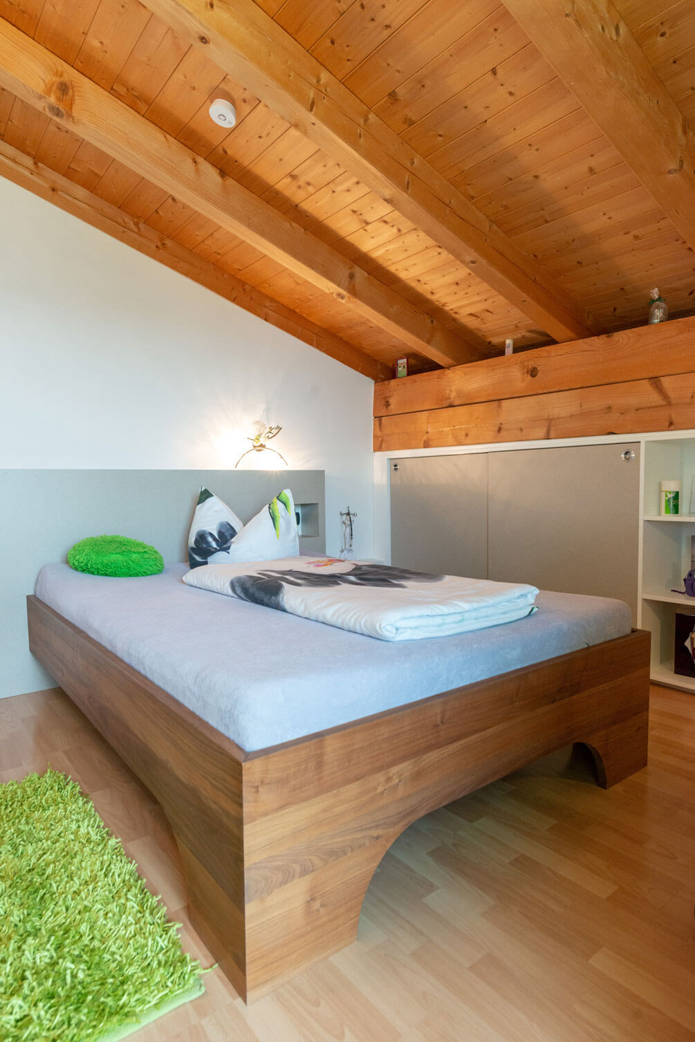 Dachbodenzimmer mit Holzbett und Boden