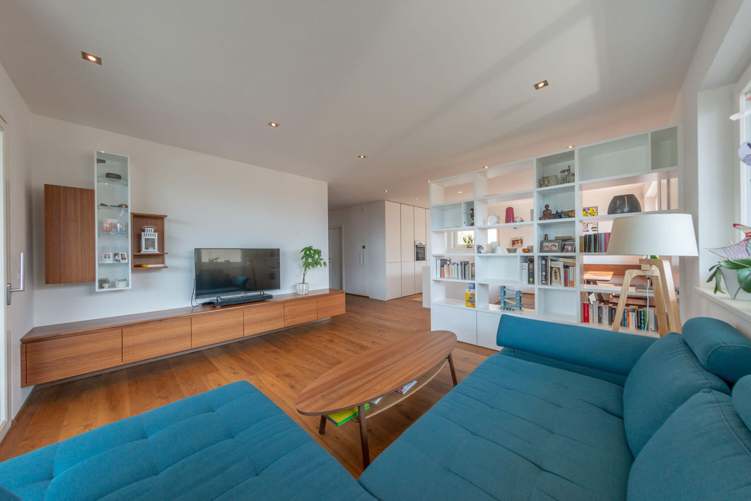 Wohnzimmer mit Holzboden, Holztisch und hölzernem Regal